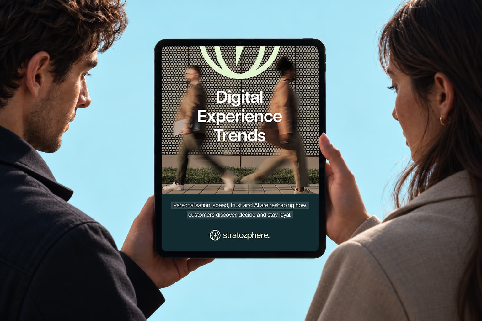 Two people holding a tablet showing the Digital Experience Trends guide